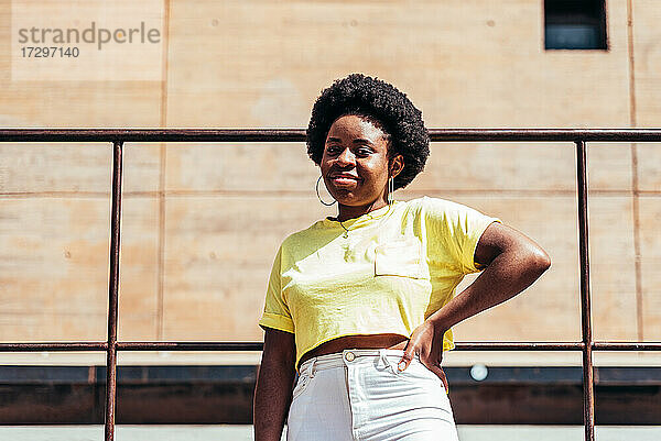 Porträt eines schwarzen Mädchens mit Afro-Haar und Ohrringen in einem urbanen Raum in der Stadt.