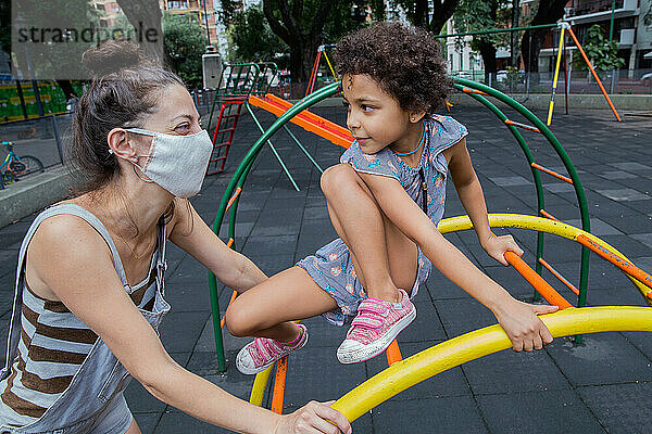 Mutter und Tochter genießen draußen auf dem Spielplatz ein neues  normales Leben.