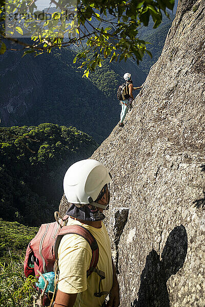 Ein paar Kletterer auf einem felsigen Berg im Regenwald im Tijuca-Park