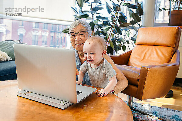 Ältere Frau sitzt mit ihrer Enkelin zusammen und führt einen Videogespräch über das Lapto