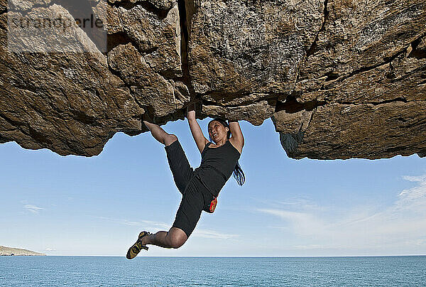 Frau beim Bouldern in einem verlassenen Steinbruch in Swanage / England