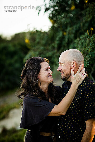 Ehemann und Ehefrau kuscheln im Garten in San Diego