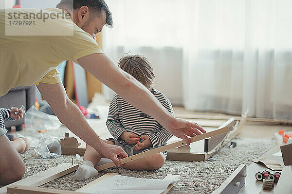 Montage von Hausmöbeln  Vater und Kinder bauen einen Tisch zusammen
