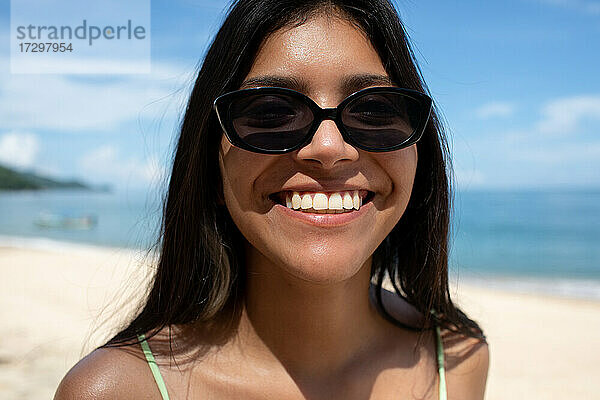 Junge Latina Frau lächelnd am Strand