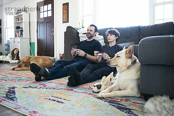 Vater und kleiner Sohn spielen zusammen Videospiele.