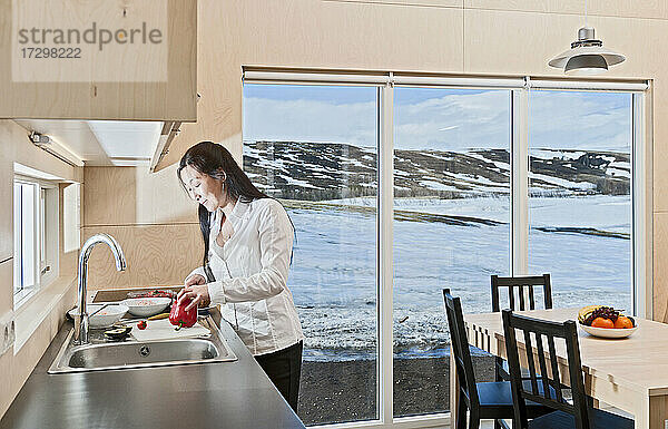 Frau bereitet Essen in isländischem Ferienhaus zu
