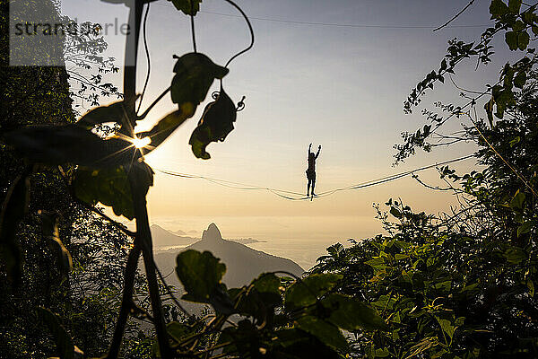 Schöne Aussicht auf männliche Highliner Silhouette auf Berg Sonnenaufgang