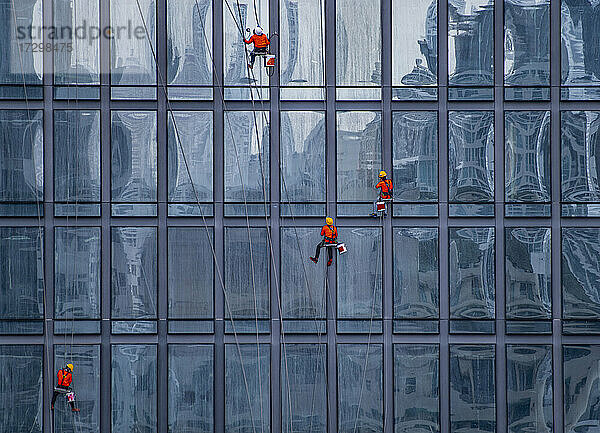 Fensterputzer bei der Arbeit an der Fassade eines Hochhauses in Bangkok