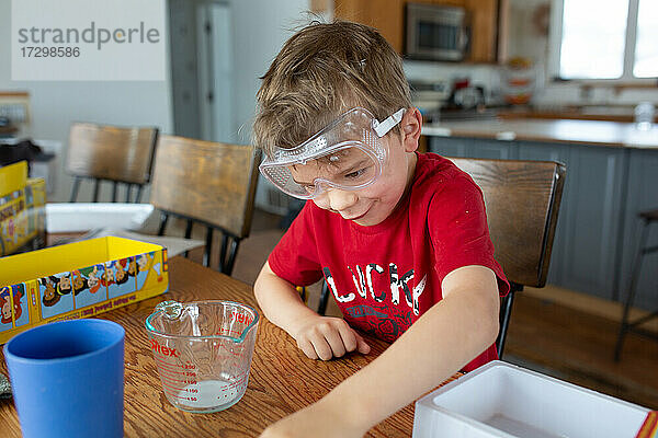 Kind macht lustiges Gesicht bei der Durchführung eines wissenschaftlichen Experiments