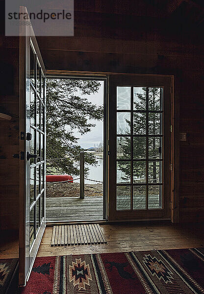 Innenansicht durch eine offene Tür mit Blick auf Wald und Wasser  Küste von Maine