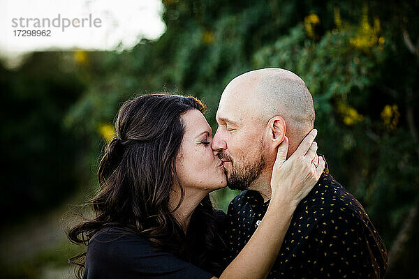 Ehemann und Ehefrau küssen sich im Garten in San Diego