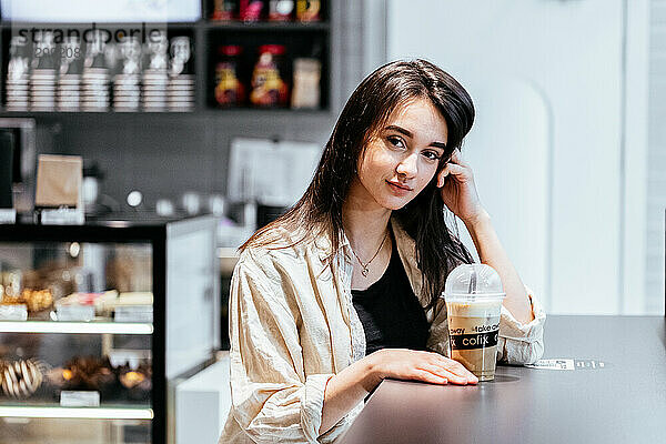 Mädchen in einem Kaffeehaus mit Kaffee zum Mitnehmen