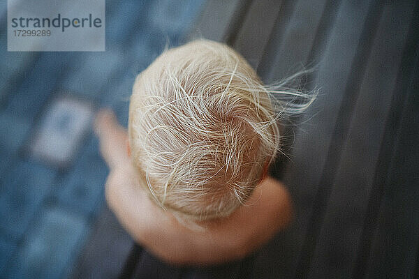 Draufsicht auf blondes Haar eines Kindes im Wind im Sommer
