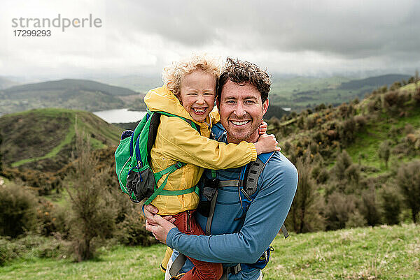 Glücklicher Vater und lächelnder Sohn bei einer Wanderung in Neuseeland