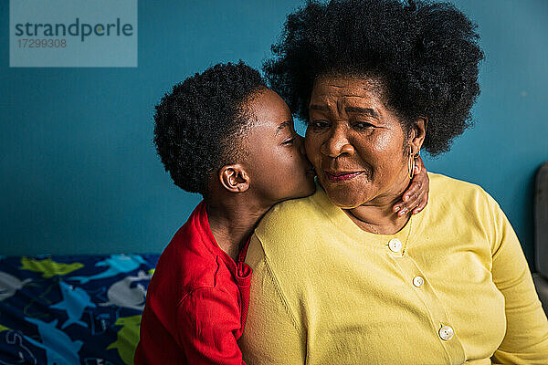 Enkel küsst seine Großmutter liebevoll auf die Wange