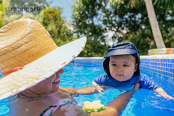Kleines Baby hat Spaß mit seiner Mutter im Schwimmbad
