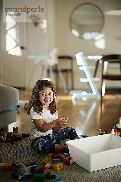 Porträt des niedlichen Mädchens lächelnd beim Spielen mit Spielzeug zu Hause