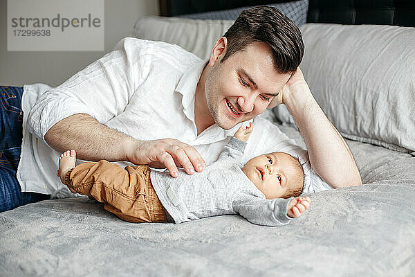 Vatertag Urlaub. Glücklich stolzer Vater spielen mit neugeborenen Baby-Jungen.