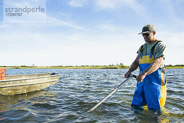 Mann bei der Arbeit auf dem Wasser in einer Aquakultur-Austernzucht