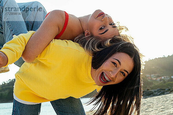 Lächelnde Mädchen haben Spaß zusammen am Strand