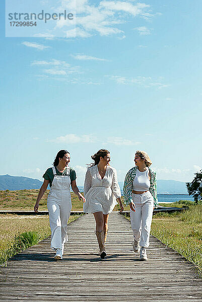 Drei schöne Mädchen  die spazieren gehen und glücklich aussehen