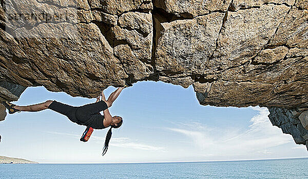 Frau beim Bouldern in einem verlassenen Steinbruch in Swanage / England