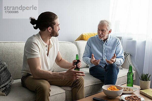 Enkel und Großvater unterhalten sich auf dem Sofa