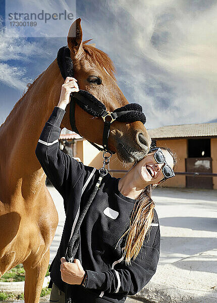Pferderennjockey mit ihrem Pferd  das sie küsst  streichelt und umsorgt