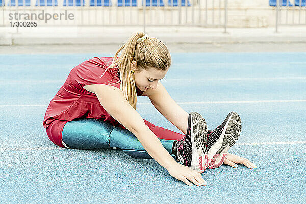 Sportlerin mit Prothese streckt die Beine