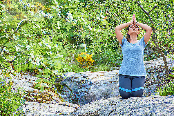 Weiße  kaukasische Frau mit langen Haaren praktiziert Yoga in der Natur. Ruhe und Entspannung