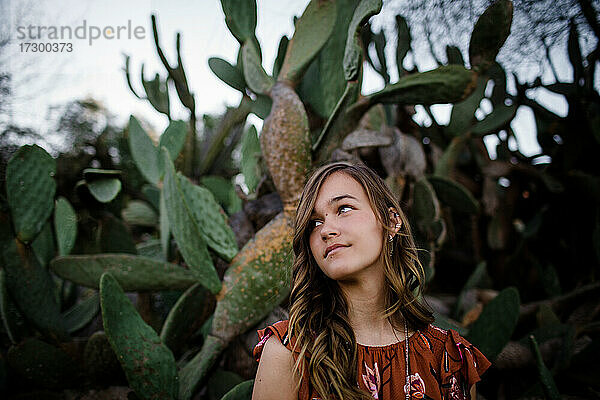 Teenager-Mädchen posiert vor einem Kaktus in San Diego