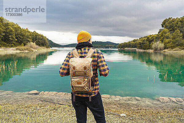 Tourist schaut von seinem Rücken auf den schönen und ruhigen türkisfarbenen See