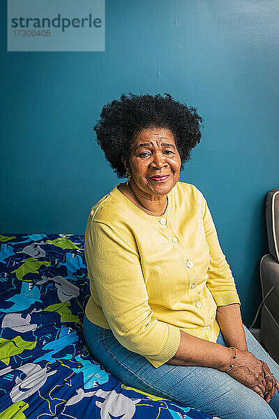 Porträt einer entspannten älteren Frau  die zu Hause im Schlafzimmer sitzt
