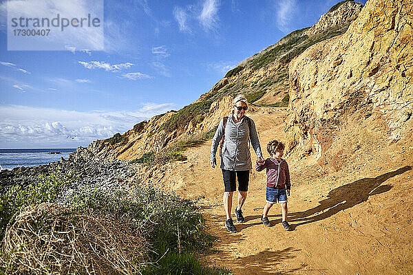 Ältere Frau wandert mit Enkel an einem sonnigen Tag