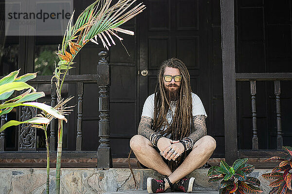 Hipster-Typ mit Dreadlocks und Tattoo am Strand in Thailand