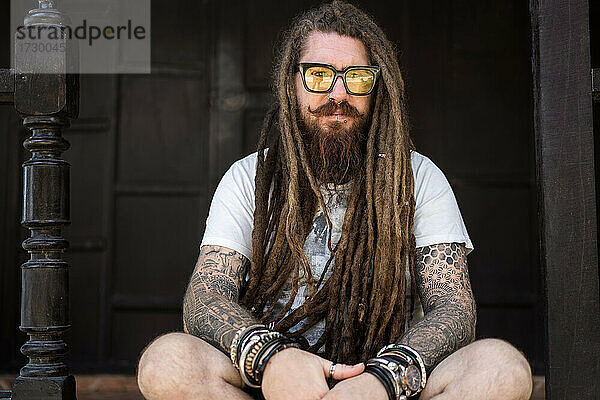 Hipster-Typ mit Dreadlocks und Tattoo am Strand in Thailand