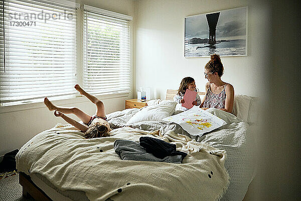 Tochter schenkt ihrer Mutter eine Grußkarte auf dem Bett zu Hause