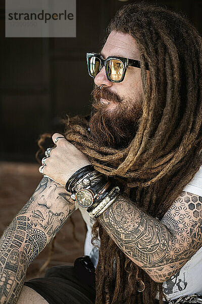 Hipster-Typ mit Dreadlocks und Tattoo am Strand in Thailand