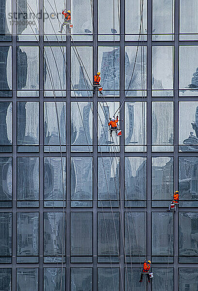 Fensterputzer bei der Arbeit an der Fassade eines Hochhauses in Bangkok