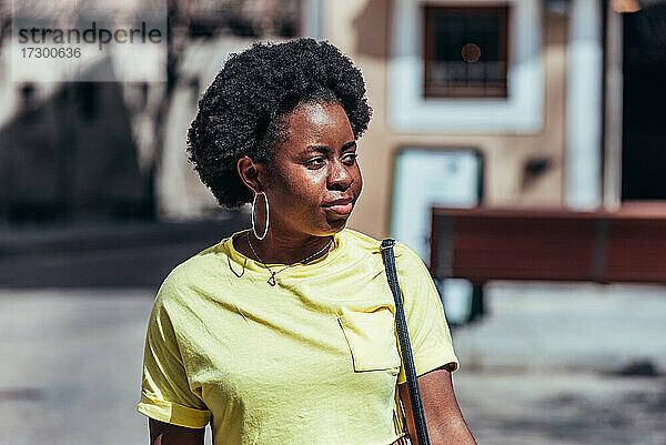 Porträt eines schwarzen afro-amerikanischen Mädchens  das eine Straße in der Altstadt entlanggeht.