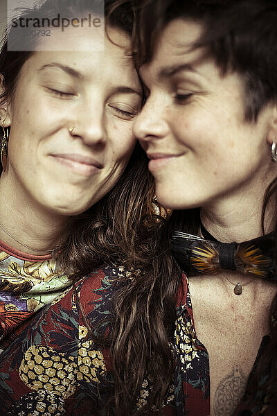 Lächelnde junge schöne Frauen teilen einen liebevollen intimen Moment