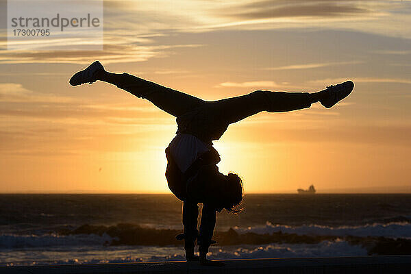 Ein Mädchen macht Stunts mit der Sonne im Hintergrund