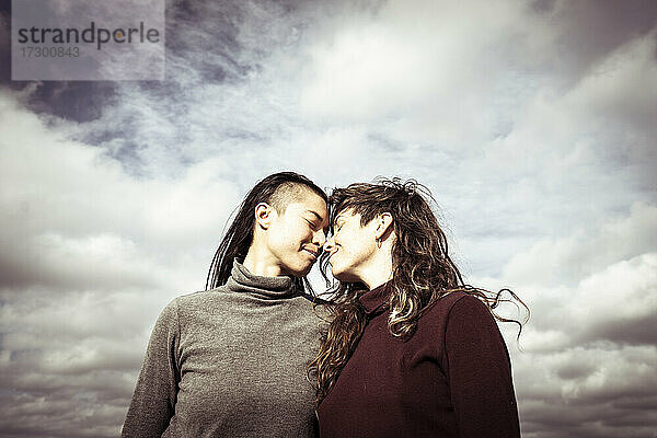 lesbisches queeres pärchen lächelt und verbindet sich unter freiem himmel in berlin