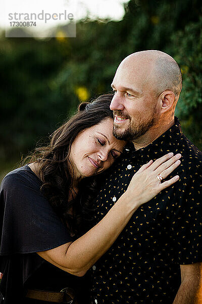 Ehemann und Ehefrau kuscheln im Garten in San Diego