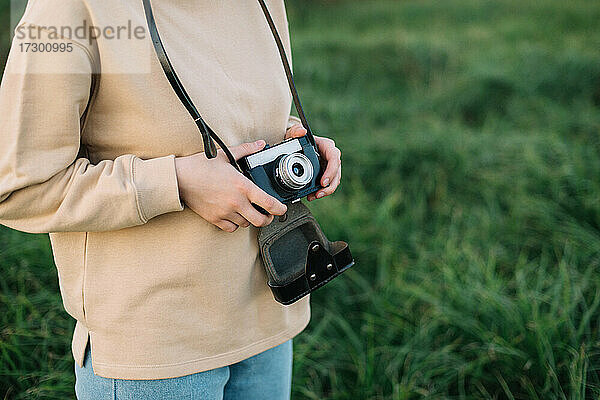 Hübsche Frau hält Filmkamera in einem Feld
