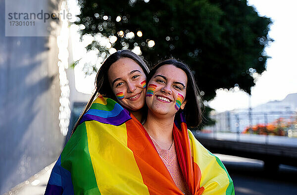 schönes lesbisches Paar  das sich auf der Straße mit einer lgtb-Fahne amüsiert