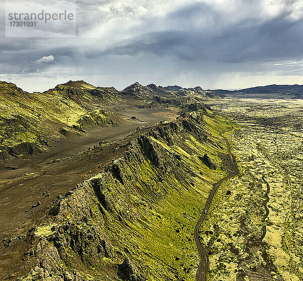 Luftaufnahme der Berge in der Nähe der Straße und des trockenen Geländes an einem bewölkten Tag in Island