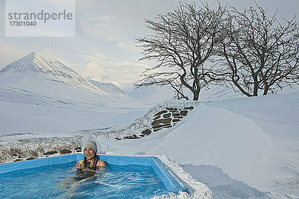 Frau genießt Whirlpool in Skihütte in Island