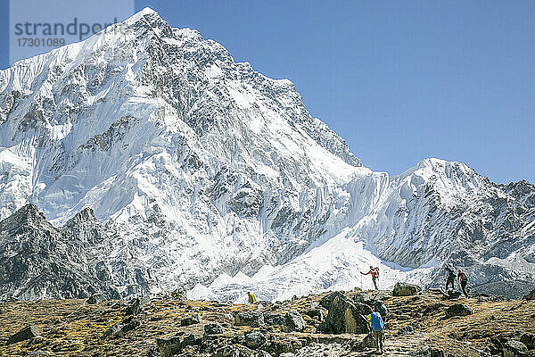 Bergsteiger auf dem Weg zum Everest Basecamp  im Hintergrund der Nuptse