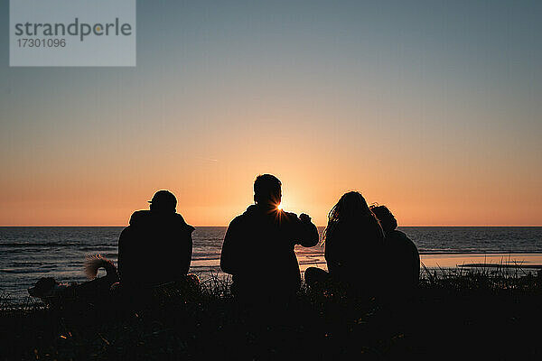 Freunde genießen einen Sonnenuntergang am Strand